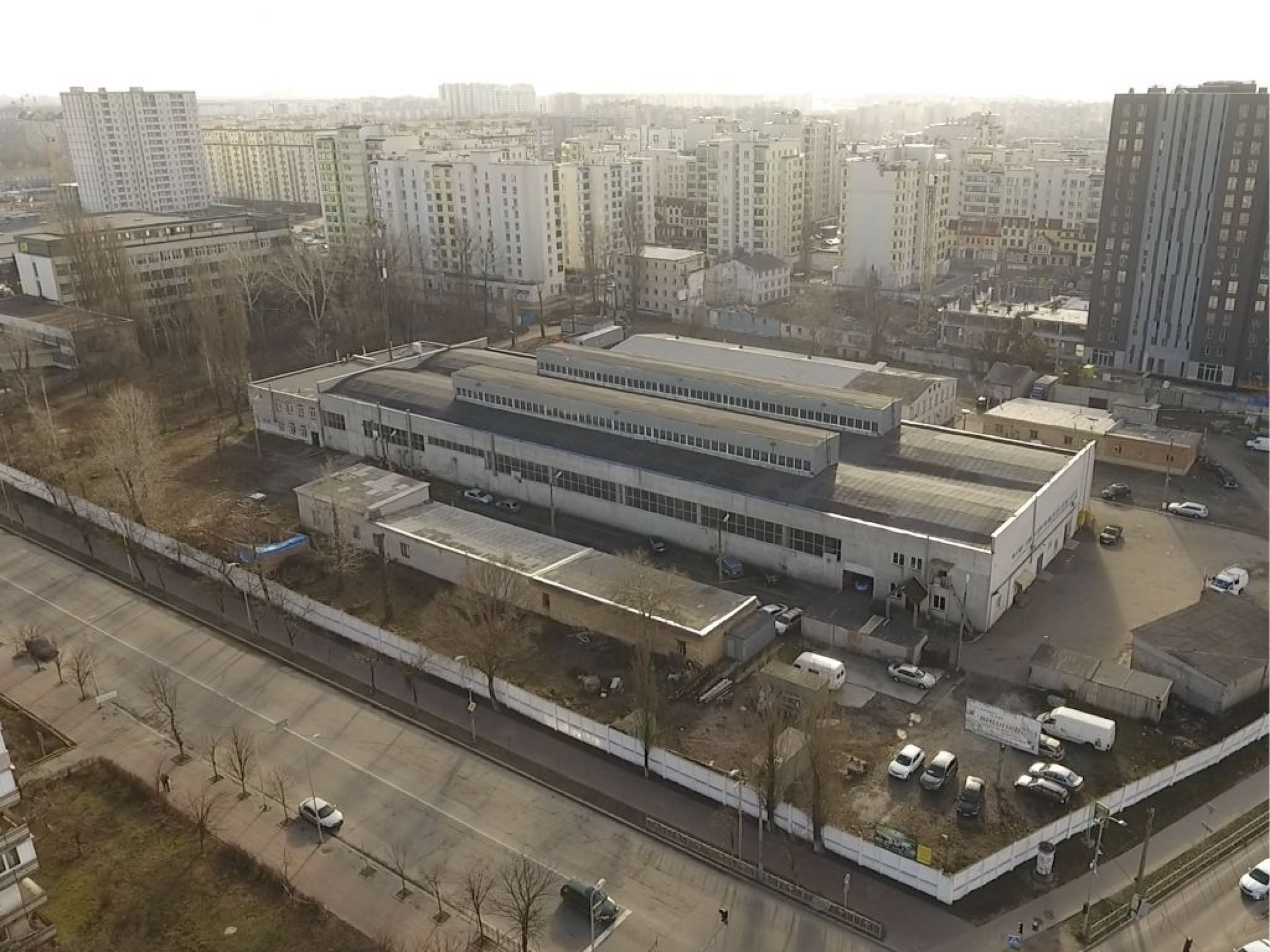Аерофотозйомка комплексу: довгі корпуси з ліхтарями на покрівлі, огороджена територія вздовж вулиці, за парканом - житлові квартали Вишневого